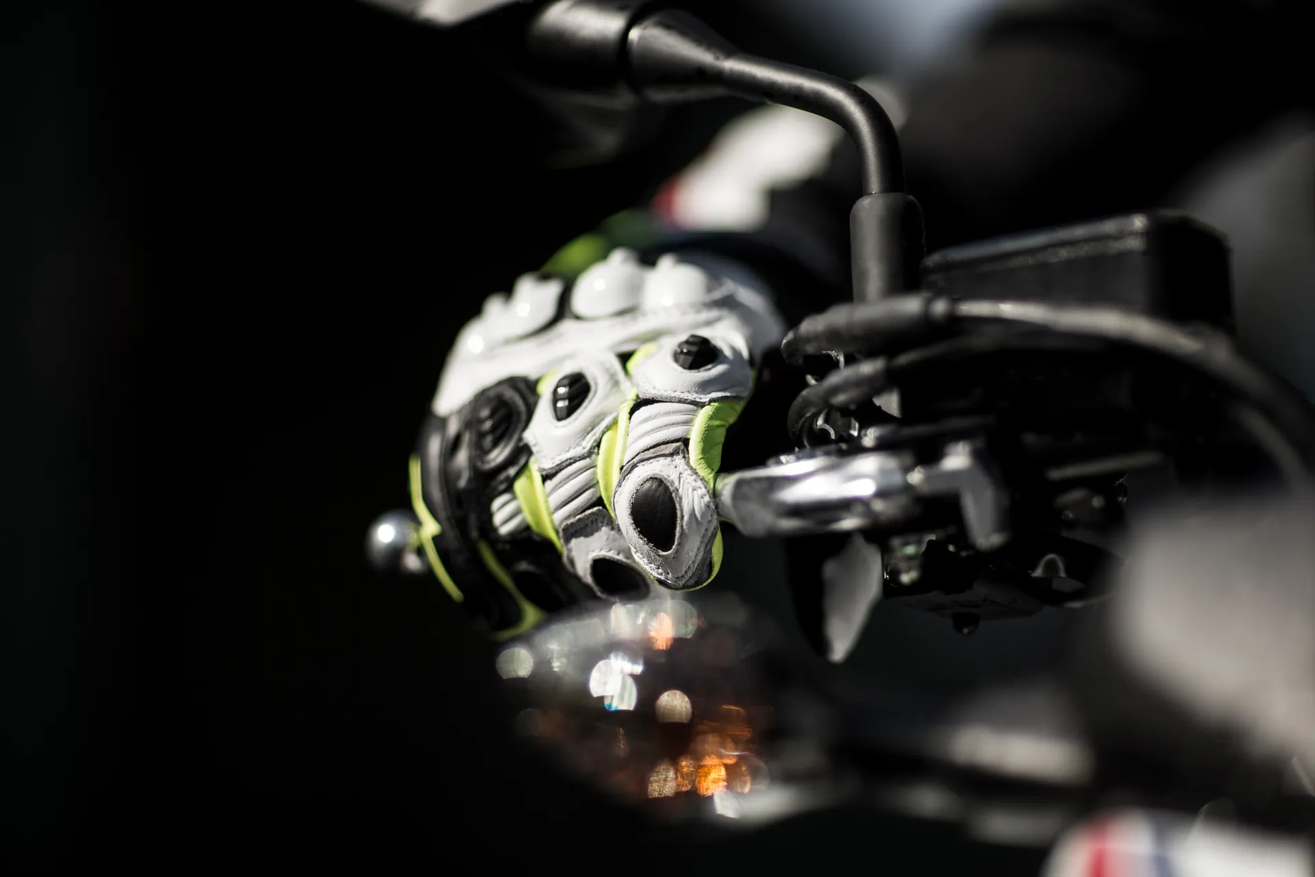 Close-up of a hand wearing a glove while holding a motorcycle handle